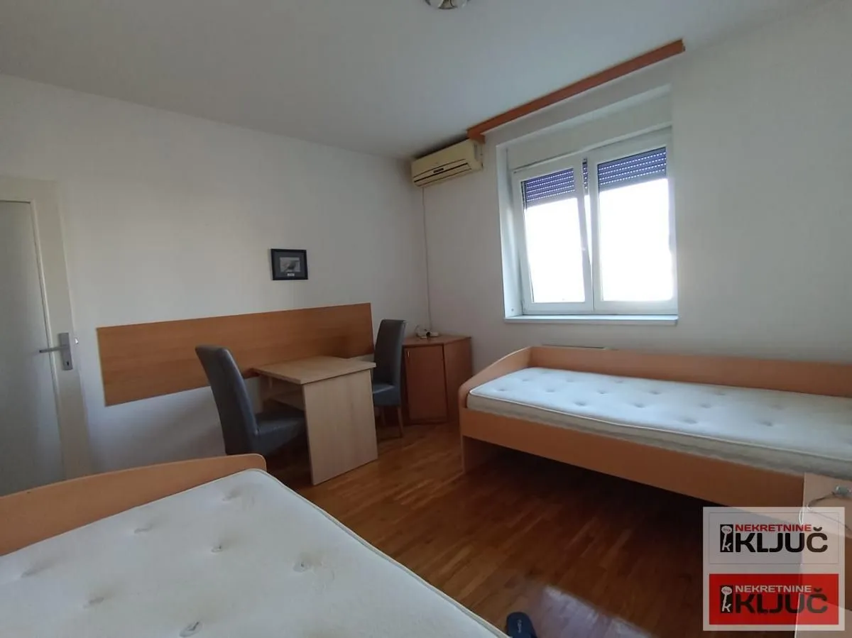 Bedroom with two single beds, a desk, and a window.