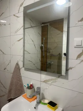 Modern bathroom equipped with a sink and a shower cabin. - image 8
