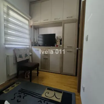 Manja soba sa ugradnim ormarima, televizorom i stolicom pored prozora. - image 7
