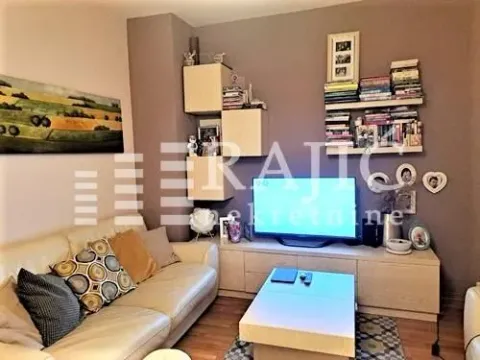 Living room with a sofa, TV, and bookshelves. - image 5
