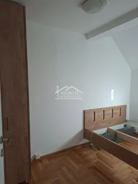 Manja spavaća soba sa drvenim krevetom i ormarom. - image 14