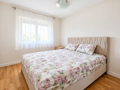 Bedroom with a double bed and a window with white curtains. - image 2