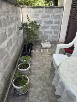 Smaller tiled balcony with potted plants and patio furniture. - image 13