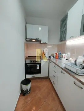 Manja opremljena kuhinja sa belim elementima i ugradnim šporetom. - image 8