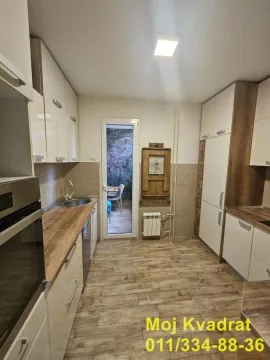 Opremljena kuhinja sa drvenim elementima i izlazom na terasu. - image 6
