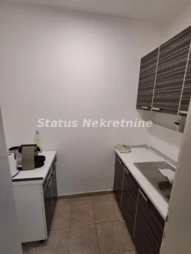 Manja kuhinja sa elementima u tamnoj boji i belim radnim površinama. - image 12