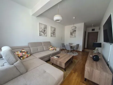 Living room with a sofa, coffee table, and dining area. - image 2