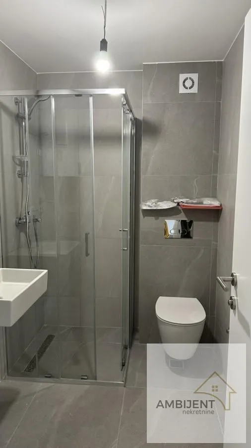 Moderno kupatilo sa tuš kabinom i ugradnim sanitarijama.
