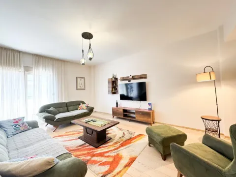 Prostrani dnevni boravak opremljen garniturom, TV-om i tepihom. - image 2