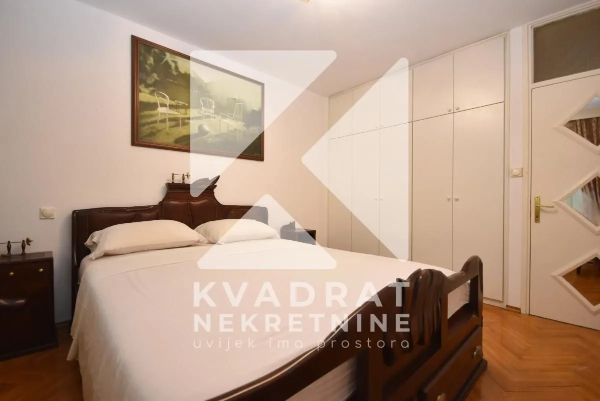 Furnished bedroom with a double bed, fitted wardrobe and a painting on the wall.