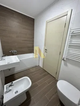 Modern bathroom with a bathtub, washbasin, and bidet. - image 12