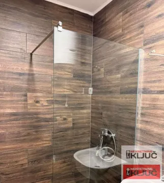 Kupatilo sa tuš kabinom i zidnim pločicama u dezenu drveta. - image 7