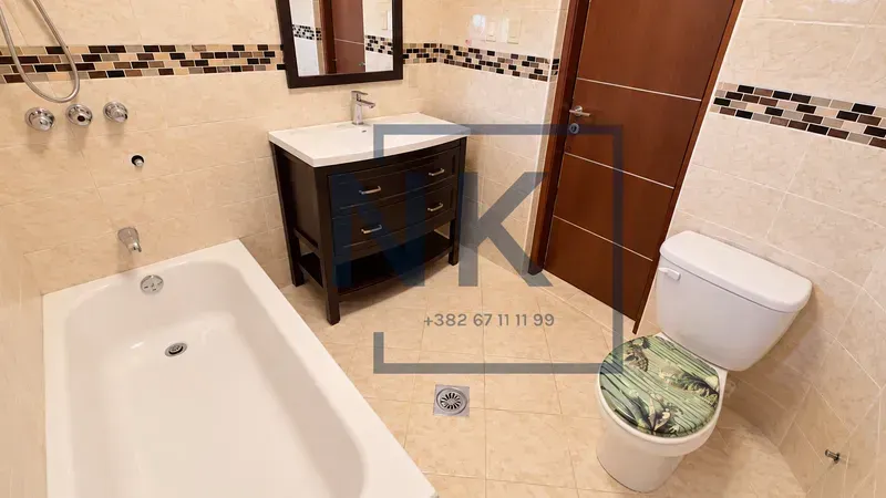 Bathroom equipped with a bathtub, vanity sink, and toilet.