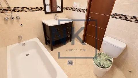Bathroom equipped with a bathtub, vanity sink, and toilet. - image 9