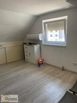 Empty room with sloping ceiling and laminate flooring. - image 13