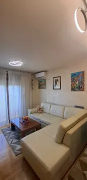 Dnevna soba sa ugaonom garniturom, stočićem i slikama na zidu. - image 6