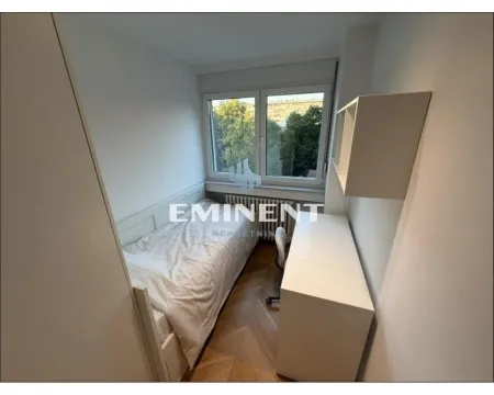 Smaller bedroom with a bed, desk, and a window. - image 13