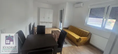 Living room with a sofa, dining table, and wardrobe. - image 2