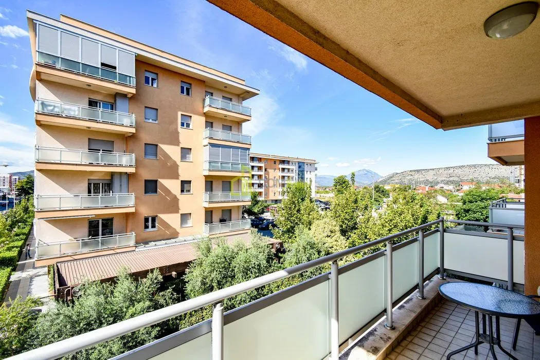 View from the balcony overlooking nearby residential buildings and greenery.