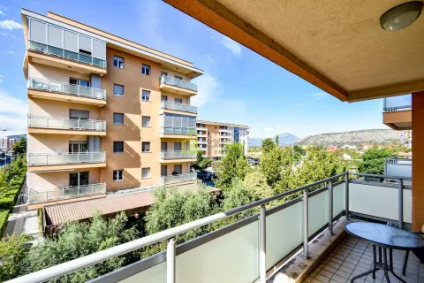 View from the balcony overlooking nearby residential buildings and greenery. - image 14