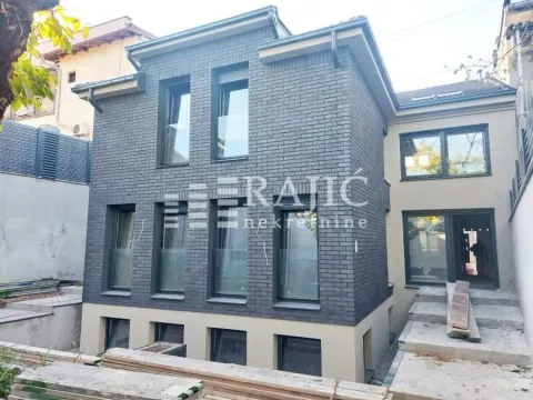 Spoljašnji izgled moderne kuće sa tamnom ciglom i uređenim dvorištem. - image 3