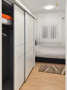 Bedroom with a large built-in wardrobe and a bed. - image 4