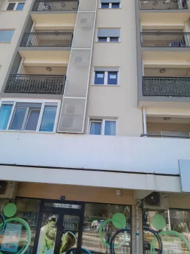 Exterior view of an apartment building with balconies and a ground floor commercial space. - image 8