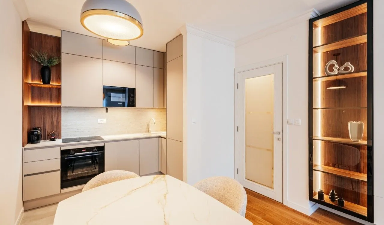 Modern kitchen with built-in appliances and a dining table.