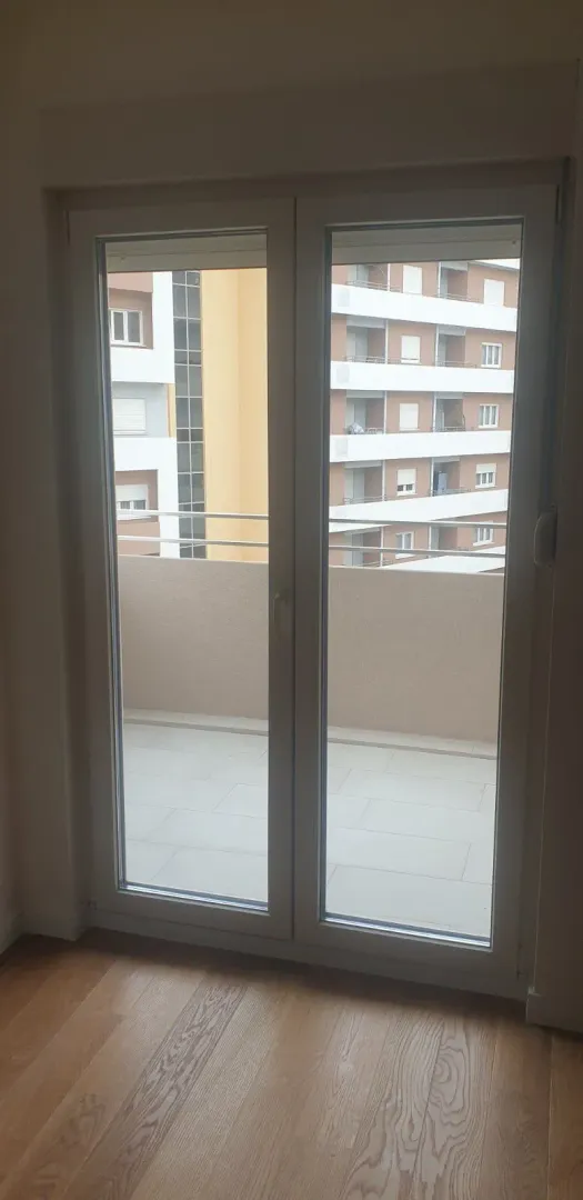 View of the balcony through double glass doors.