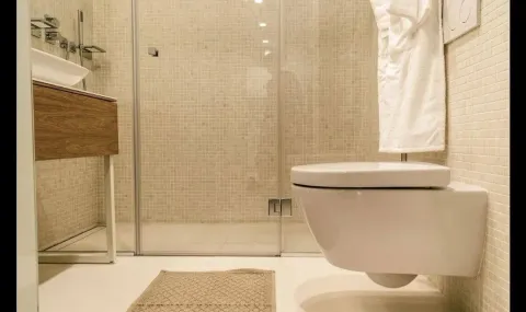 Modern bathroom with a walk-in shower and a wall-mounted toilet. - image 4