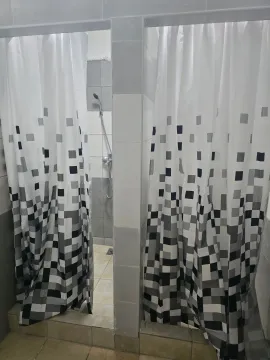 Tuš kabina sa belim zavesama sa šarama u kupatilu. - image 10