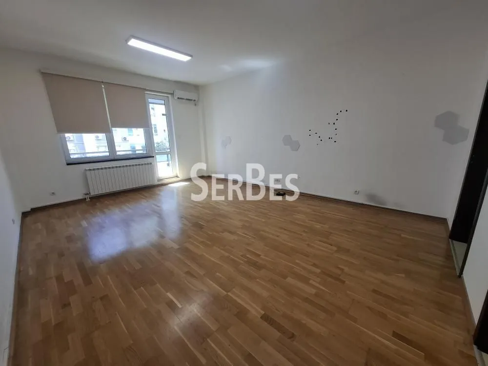Empty room with hardwood flooring and a window.