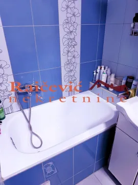 Bathroom equipped with a bathtub and blue wall tiles. - image 11