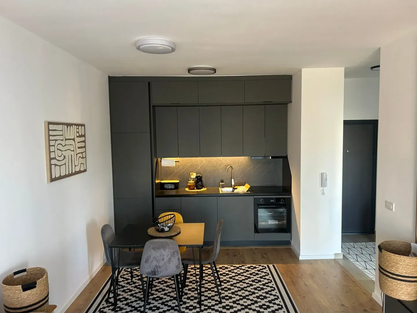 Modern kitchen with dark cabinets and a dining table.
