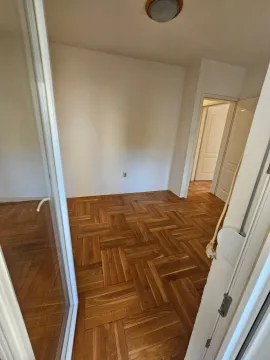 Empty room with parquet flooring and a view of the hallway. - image 6