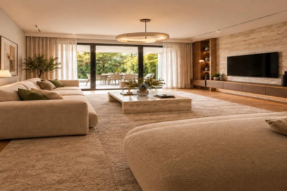 Spacious living room with a sofa set, TV, and large sliding doors with a view of greenery.