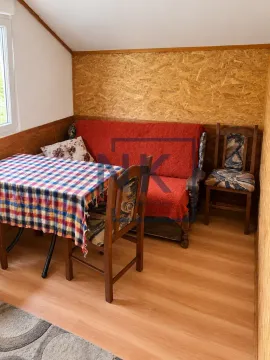 Manji dnevni boravak sa trosjedom, trpezarijskim stolom i drvenim oblogama na zidovima. - image 6