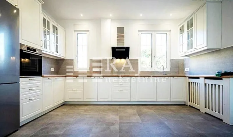 Modern kitchen with white cabinetry and built-in appliances.