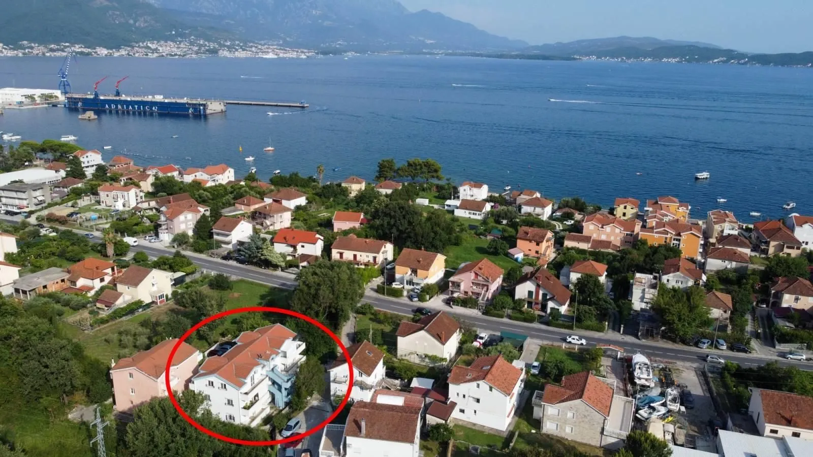 Vazdušni pogled na naselje i obalu sa označenom kućom.