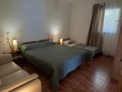 Spacious bedroom with a double bed, an extra single bed, and a sofa. - image 5