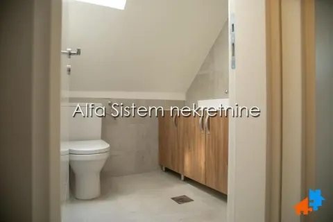 A view of the bathroom with sanitaryware and a wooden cabinet under the slanted ceiling. - image 4