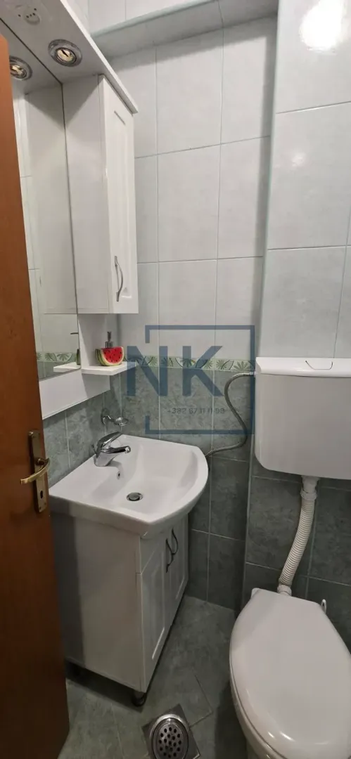 Small bathroom with a sink, mirror, cabinet, and toilet.