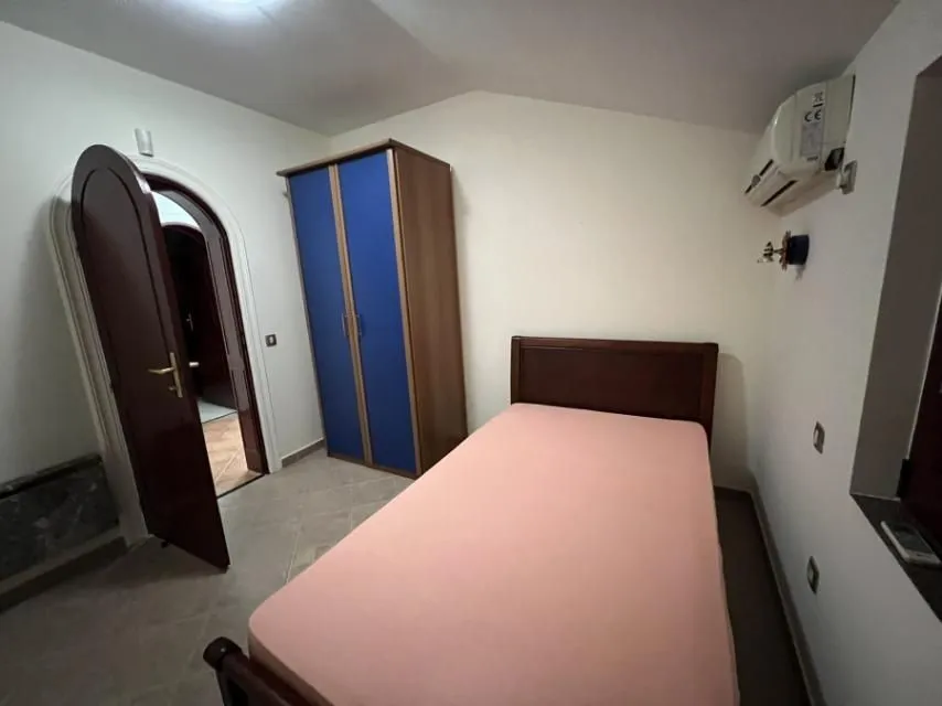 Bedroom with a bed and a blue wardrobe.