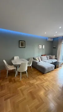 Living room with a sofa, dining table, and hardwood flooring. - image 17