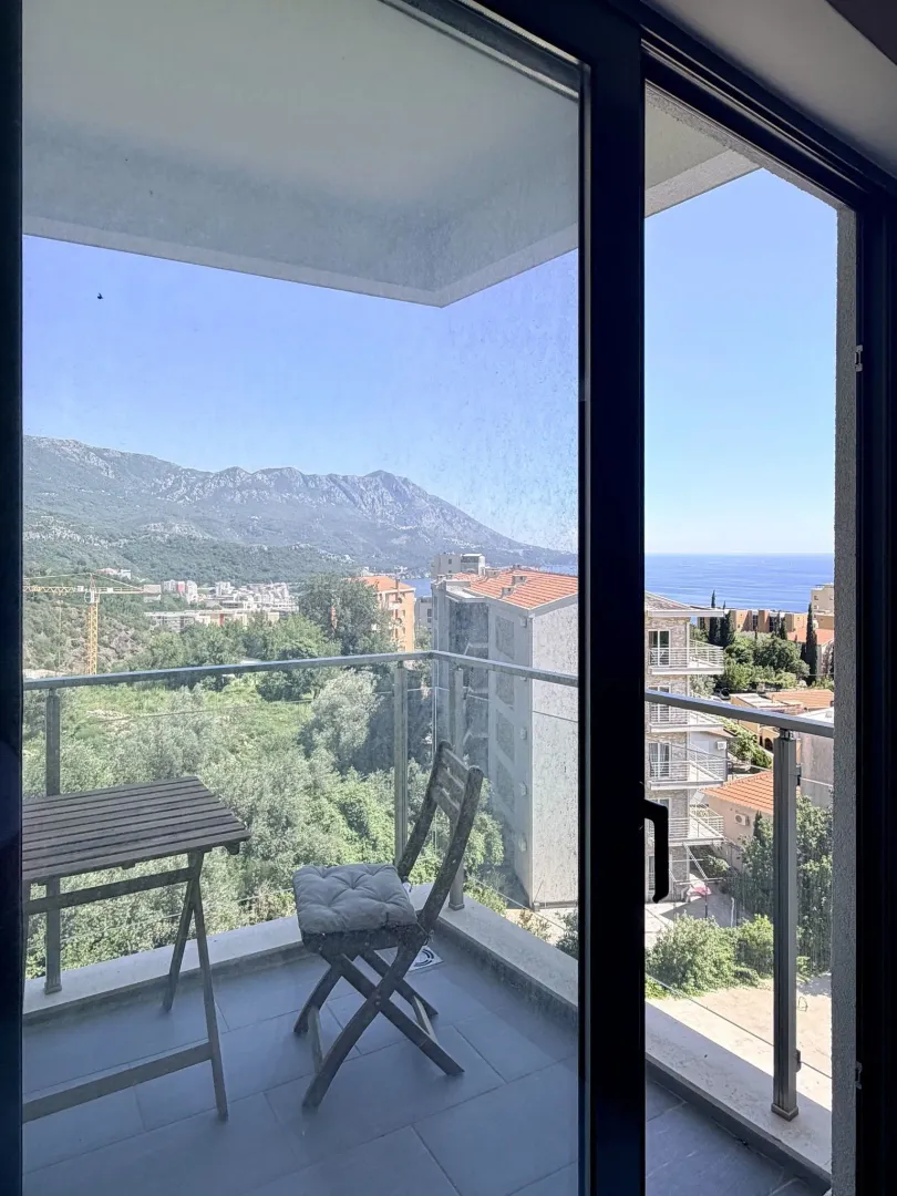 Terasa sa stolom i stolicom i pogledom na more i planine.