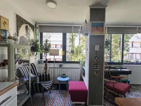 Dnevni boravak sa garniturom, velikim prozorima i dekorativnim detaljima. - image 7