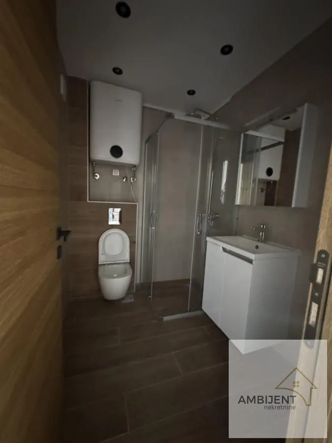 Moderno kupatilo sa tuš kabinom, umivaonikom i wc šoljom.