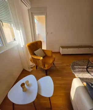 Dnevni boravak sa žutom foteljom, stočićem i izlazom na terasu. - image 4