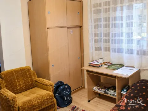 Small bedroom with a wardrobe, desk, and armchair. - image 4