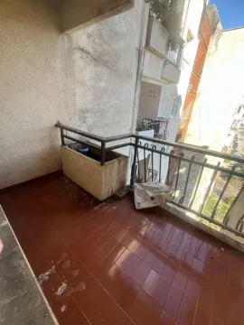 Nenamješten balkon sa popločanim podom i metalnom ogradom. - image 10